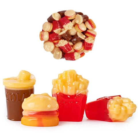 A set of novelty gummy candies shaped like fast food items, including a drink cup, hamburger, french fries in a red container, and another french fries container, with a loose pile of mixed candy pieces floating above on a white background.
