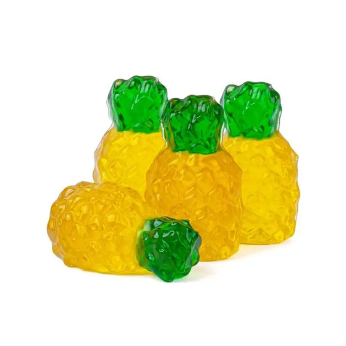 Four translucent pineapple-shaped items, likely gummy candies or decorative ornaments, arranged on a plain white background. Two are standing upright with yellow bodies and green tops, and two are lying down, showing the textured yellow surface.