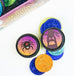 Halloween-themed Oreo-style chocolate cookies with colorful printed designs, including a spider on one cookie and a haunted house on another, arranged on a white surface with part of the product box visible in the background.